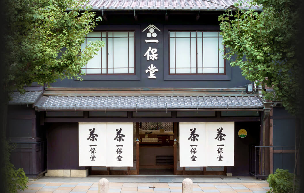 Black storefront of Ippodo Tea flagship store in Kyoto, Japan with cherry blossom trees